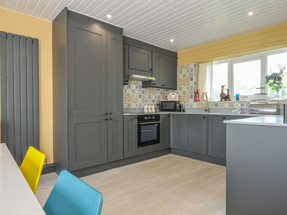 A kitchen with cabinets and appliances at 37 Tamar in St Ann's Chapel near Callington