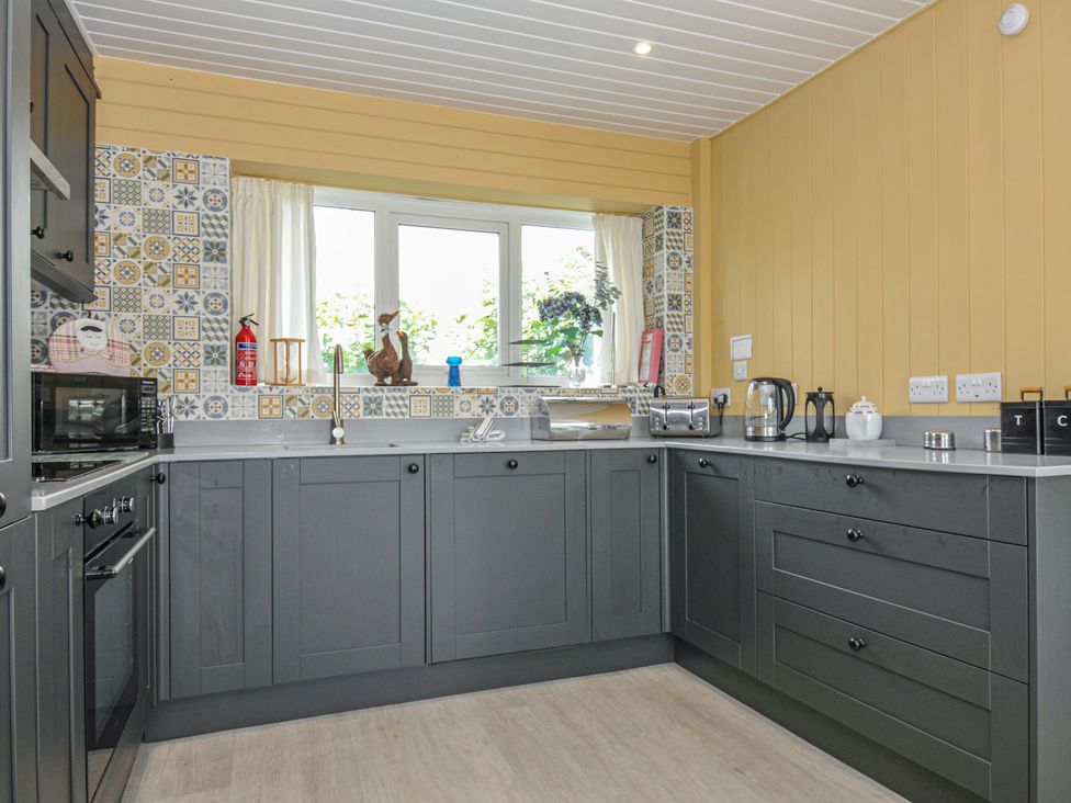 A kitchen with appliances and a window at 37 Tamar St Ann's Chapel near Callington