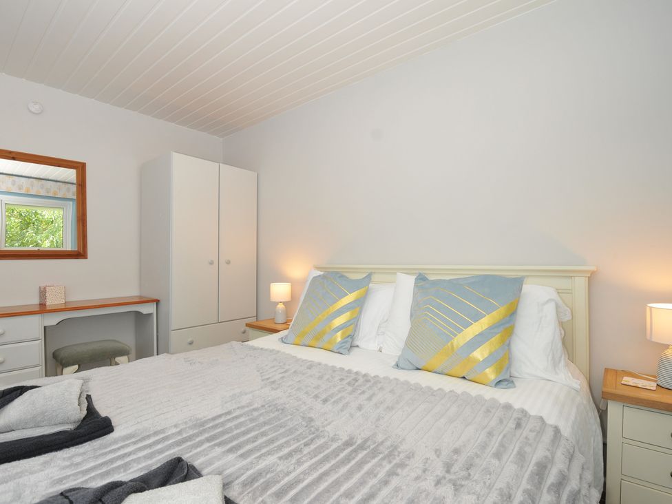 A bedroom with a bed and mirror at 37 Tamar, St Ann's Chapel near Callington