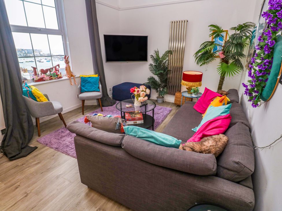 A living room with a sofa and coffee table at Harbour View in St Ives