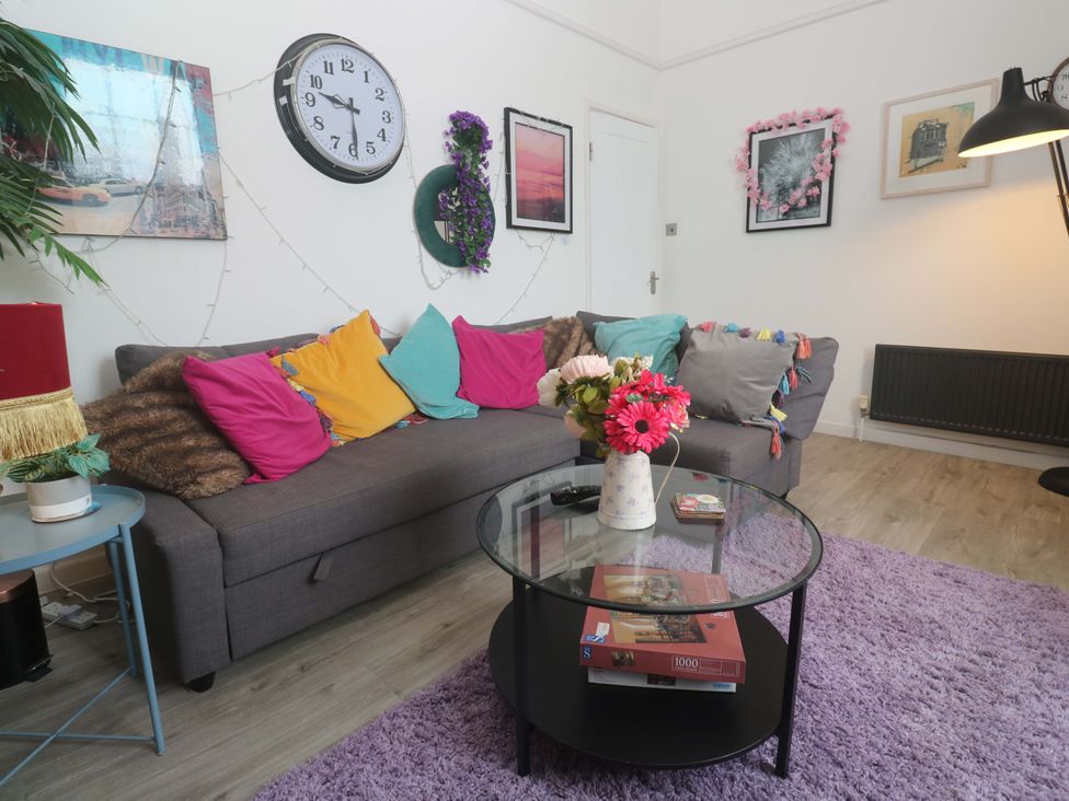 A living room with a sofa and coffee table at Harbour View in St Ives