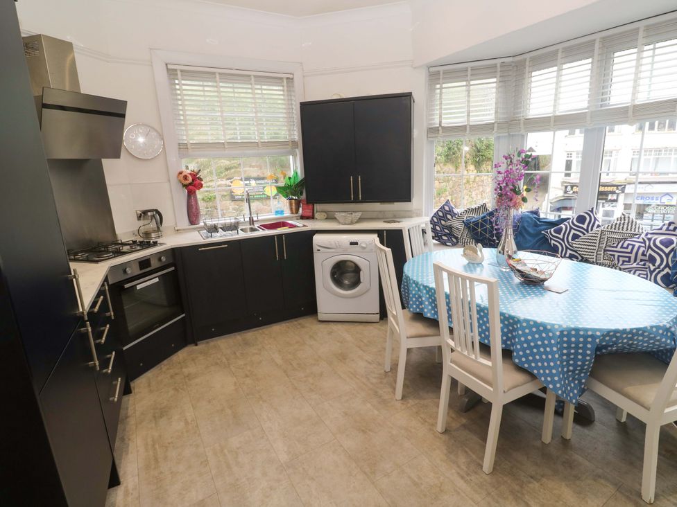 A kitchen with appliances and a dining area at Harbour View in St Ives