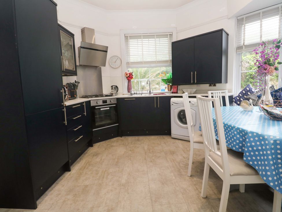 A kitchen with appliances and a dining table at Harbour View in St Ives