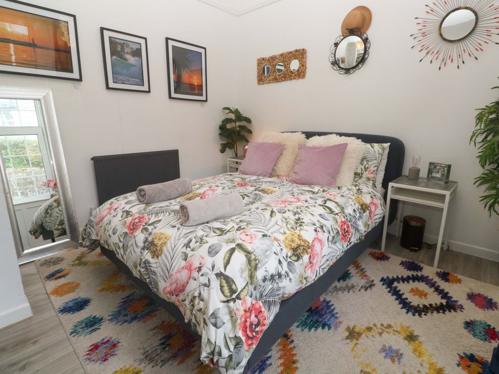 A bedroom with a bed and nightstand at Harbour View in St Ives