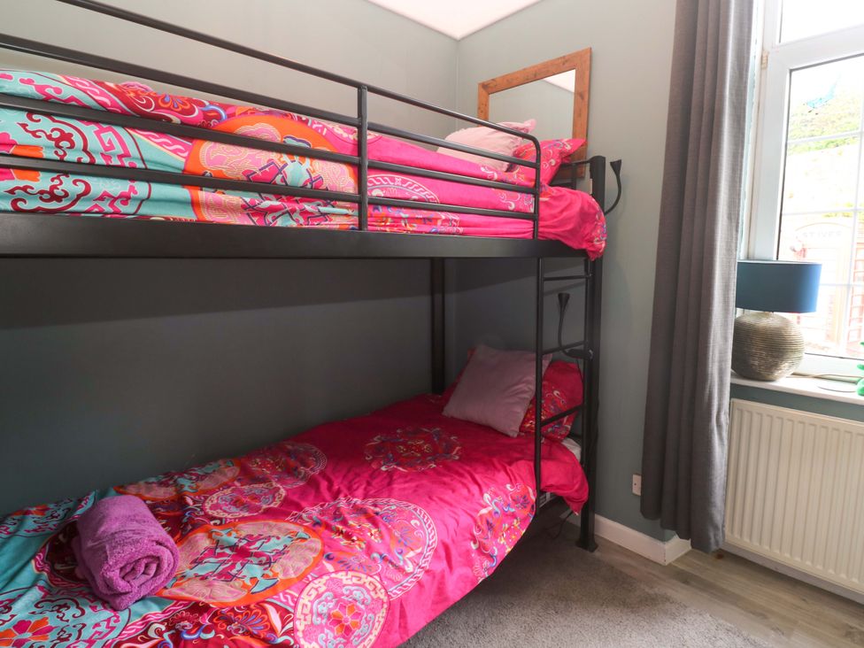 A bunk bed with colorful bedding in a bedroom at Harbour View St Ives