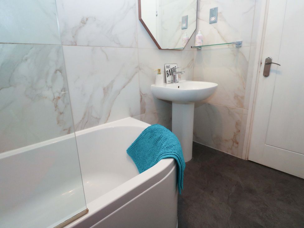 A bathroom with a bathtub and sink at Harbour View in St Ives