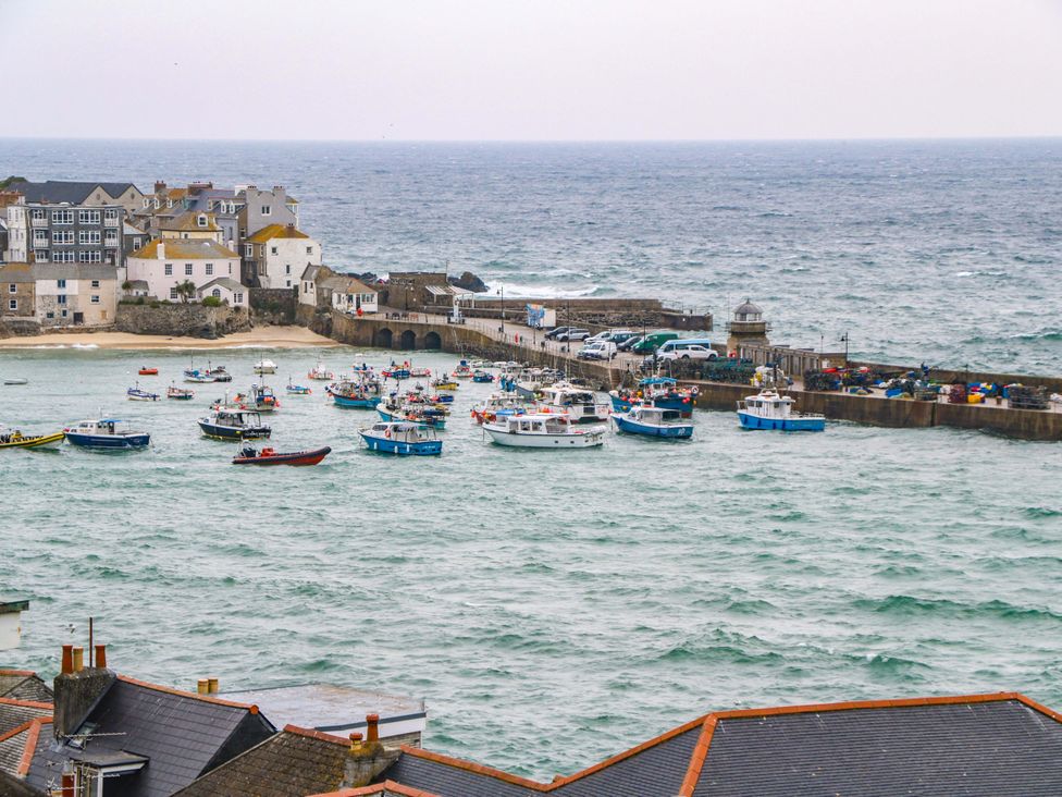 A view of boats in the ocean near a pier at Harbour View in St Ives