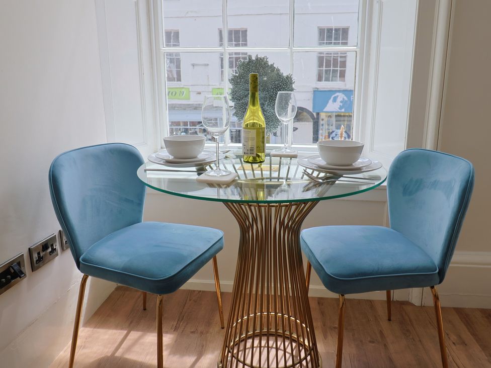 A dining room with a table and two chairs at FLAT 1 53a Broad Street (1 Bedroom Sleeping 2) Lyme Regis