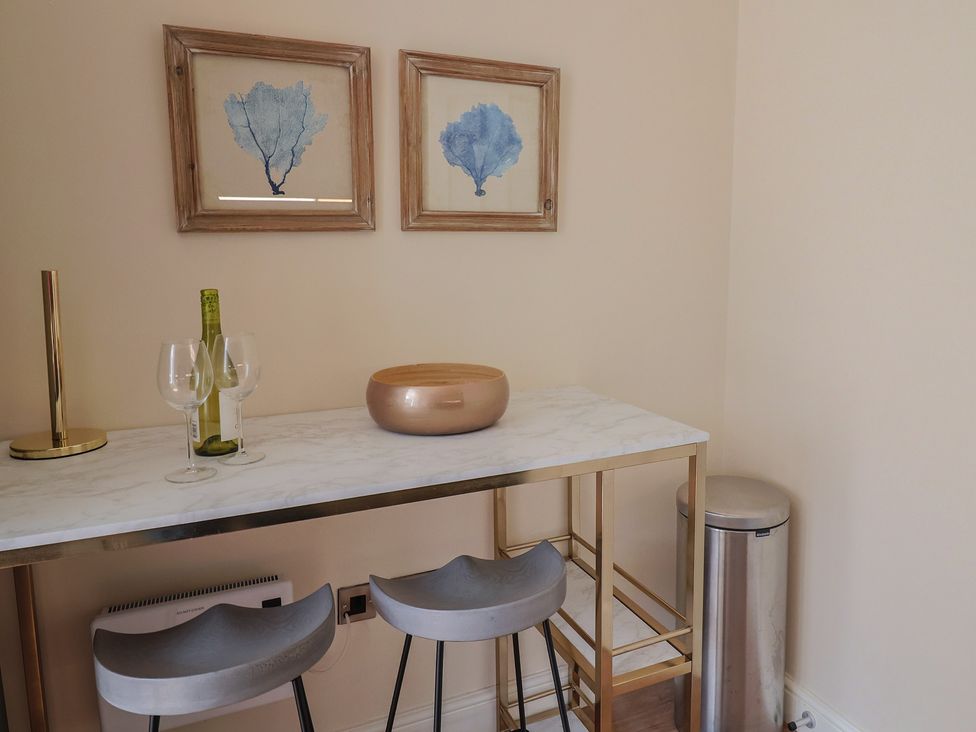 A dining room with a bar table and stools at FLAT 1 53a Broad Street (1 Bedroom Sleeping 2) Lyme Regis