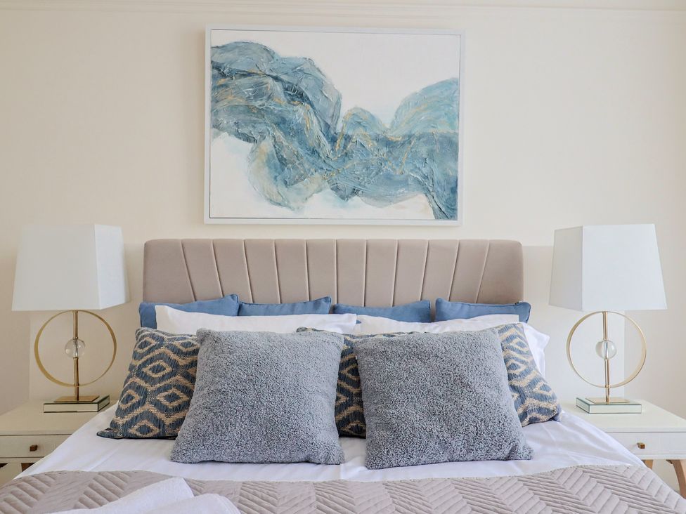 A bedroom with a bed, pillows, bedside tables, and lamps at FLAT 1 53a Broad Street (1 Bedroom Sleeping 2) Lyme Regis