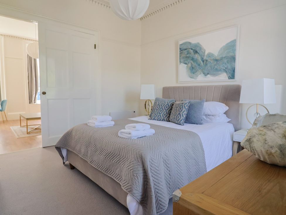A bedroom with a bed and artwork at The Tides in Lyme Regis