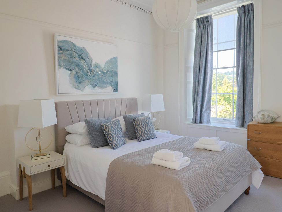 A bedroom with a bed and bedside tables at The Tides in Lyme Regis