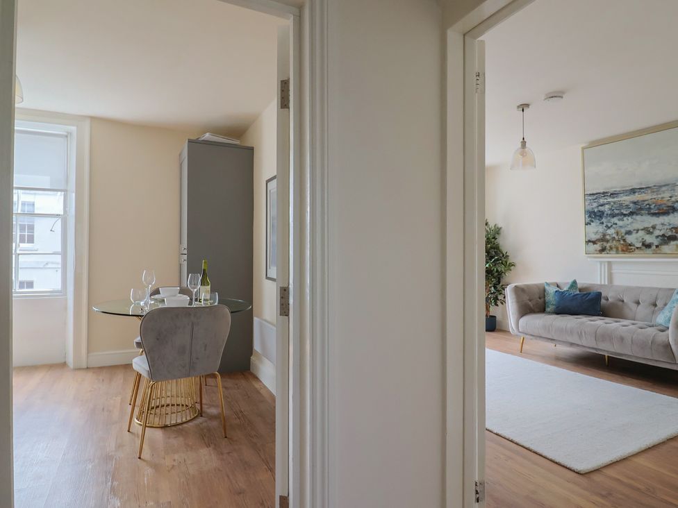 A dining area and living room with a dining table and sofa at FLAT 2 53a Broad Street (1 Bedroom Sleeping2) Lyme Regis