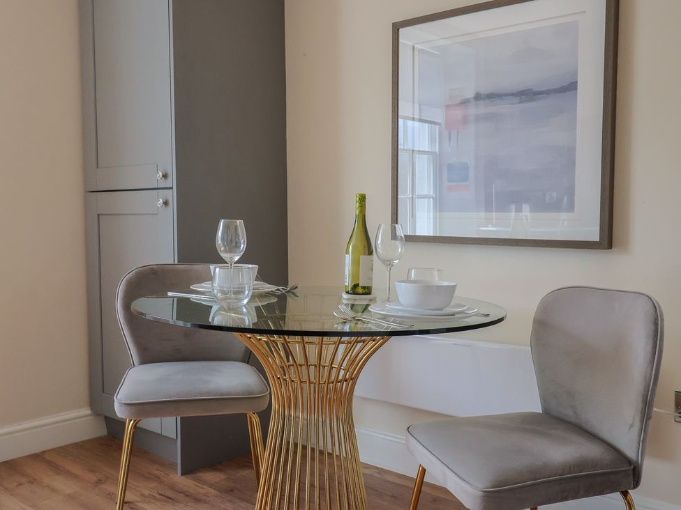 A dining room with a round table and two chairs at FLAT 2 53a Broad Street (1 Bedroom Sleeping2) Lyme Regis