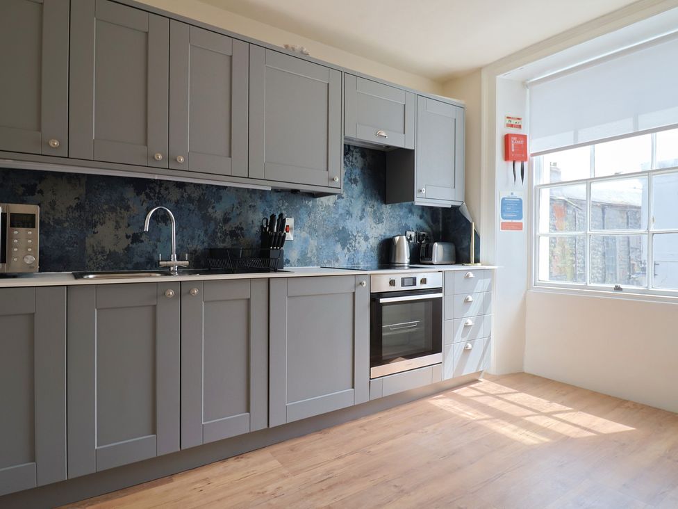 A kitchen with cabinets and appliances at FLAT 2 53a Broad Street (1 Bedroom Sleeping2) Lyme Regis