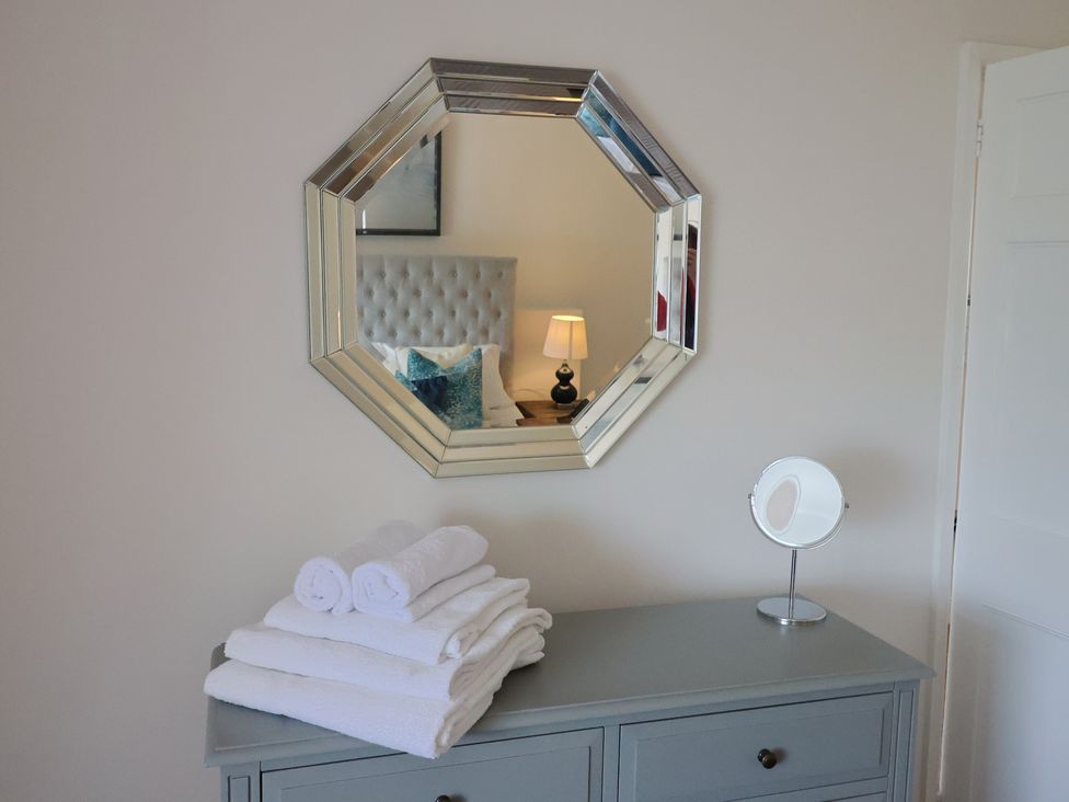 A bedroom with a mirror, towels, and a dresser at FLAT 2 53a Broad Street (1 Bedroom Sleeping2) Lyme Regis