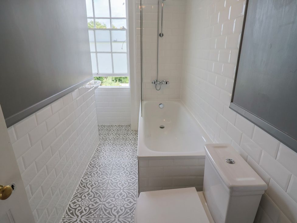 A bathroom with a bathtub and toilet at FLAT 2 53a Broad Street (1 Bedroom Sleeping2) Lyme Regis