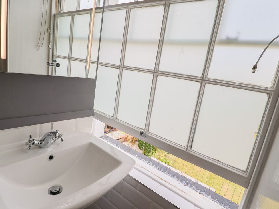 A bathroom with a sink and window at FLAT 2 53a Broad Street (1 Bedroom Sleeping2) Lyme Regis