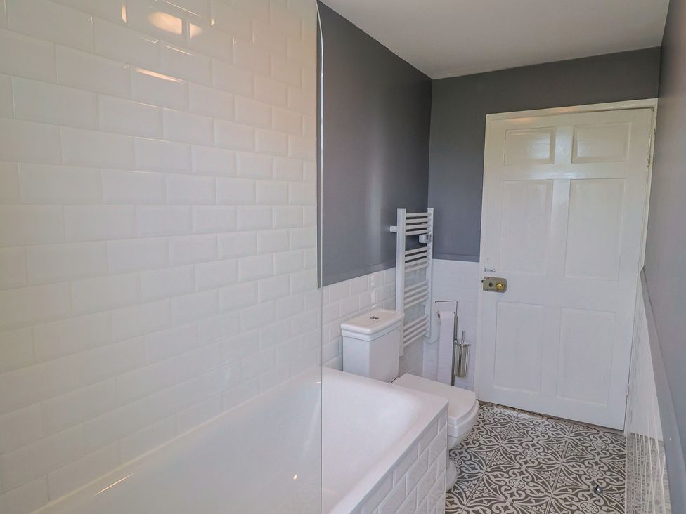 A bathroom featuring a bathtub, toilet and towel radiator at FLAT 2 53a Broad Street (1 Bedroom Sleeping2) Lyme Regis