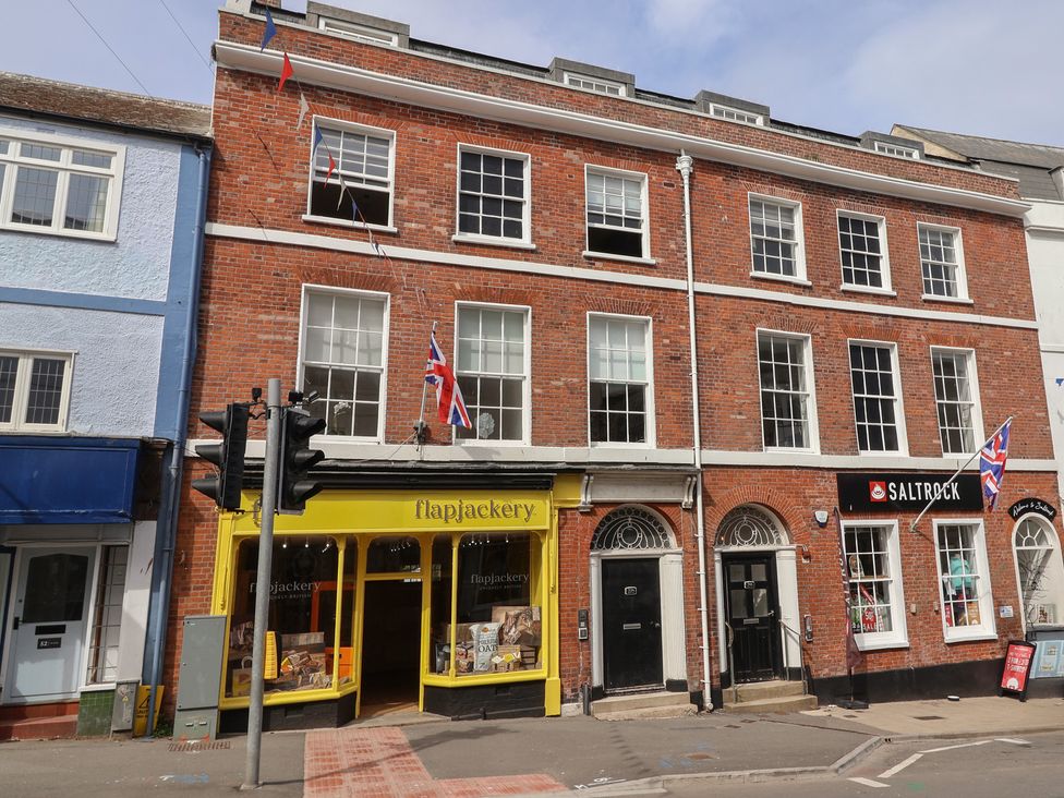 A street view of shops including Flapjackery and Saltrock at Saltwind in Lyme Regis