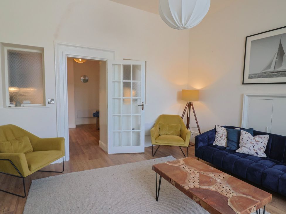 A living room with a sofa, chairs, and a coffee table at Saltwind in Lyme Regis