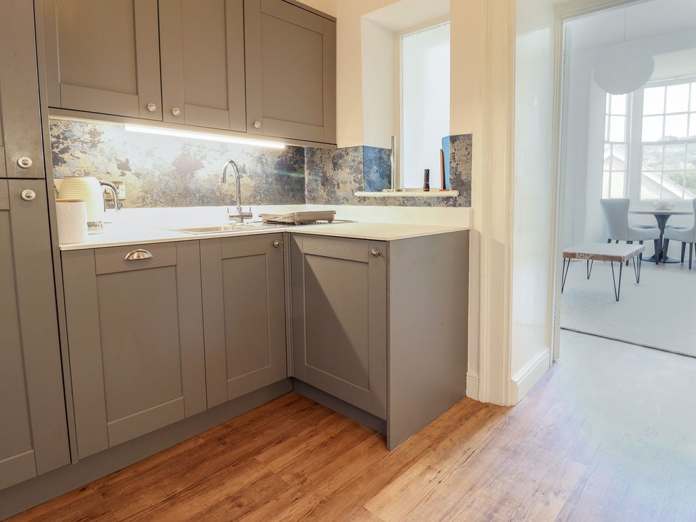 A kitchen with grey cabinets and a sink at Saltwind in Lyme Regis