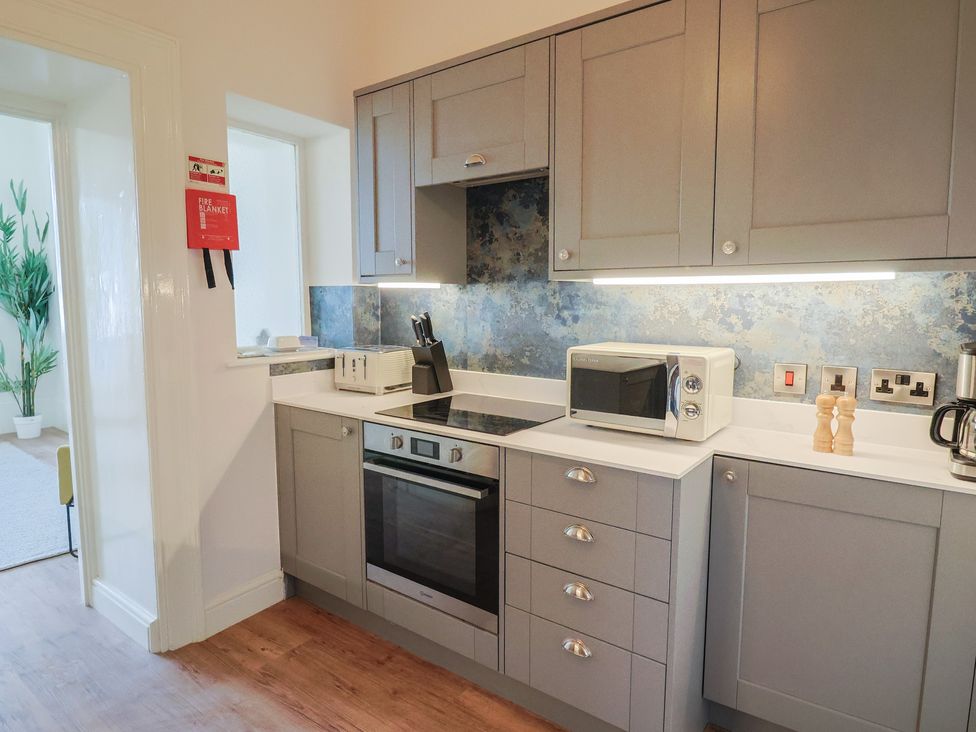A kitchen with cabinets and appliances at Saltwind in Lyme Regis