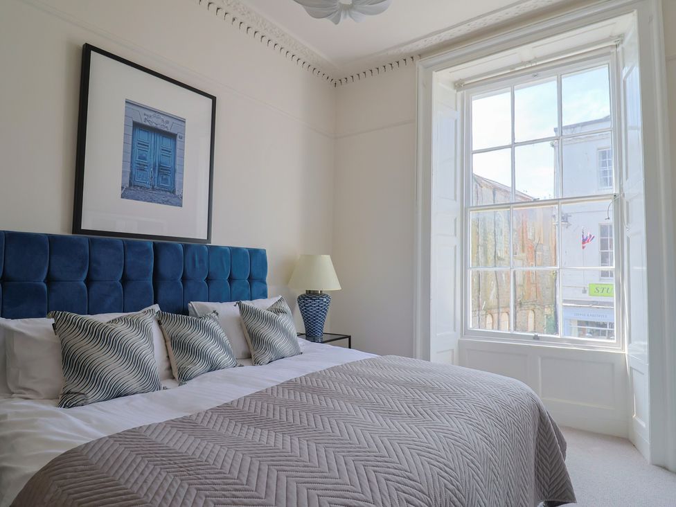 A bedroom with a bed and window at Saltwind in Lyme Regis