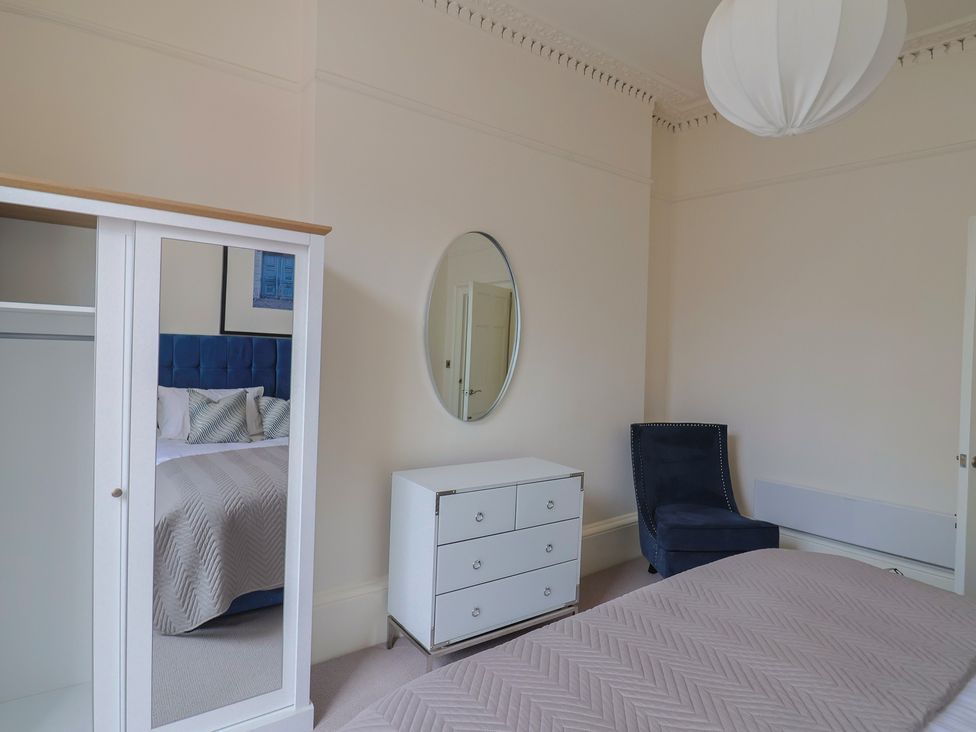 A bedroom with a wardrobe and a bed at Saltwind in Lyme Regis