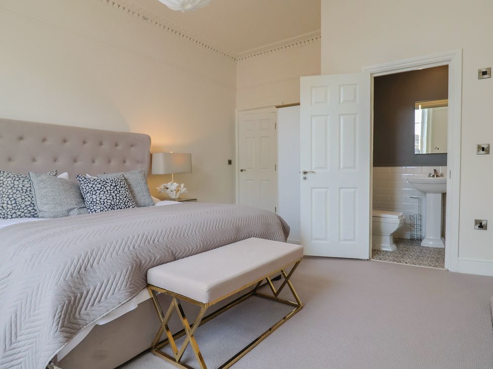 A bedroom with a bed and an en-suite bathroom at Saltwind in Lyme Regis