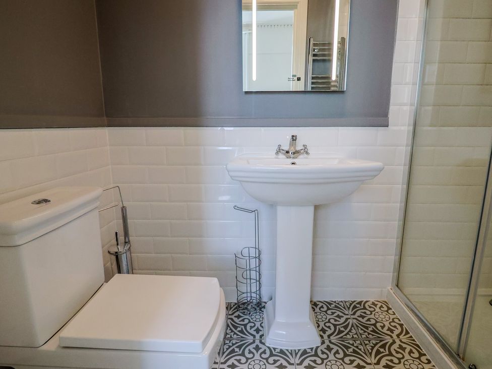 A bathroom with a toilet, sink, and shower at Saltwind in Lyme Regis