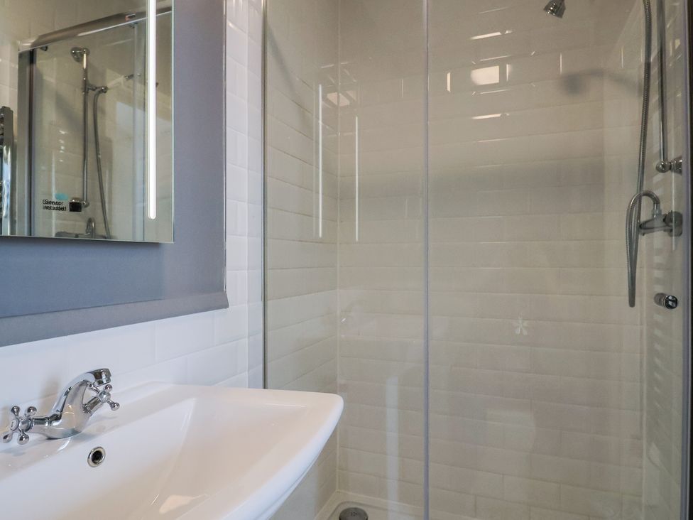 A bathroom with a shower and a sink at Saltwind in Lyme Regis