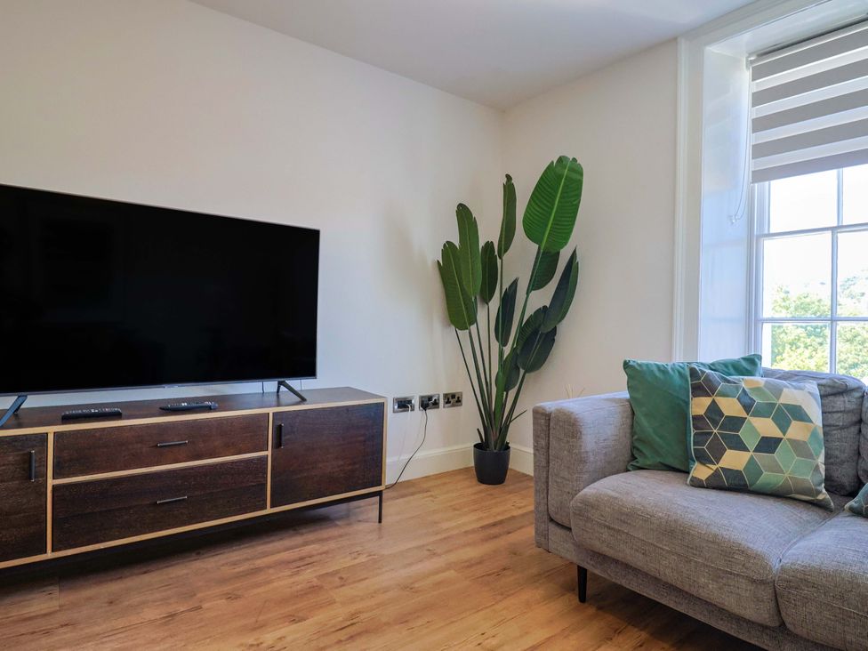 A living room with a couch and television at Pebble Cove in Lyme Regis