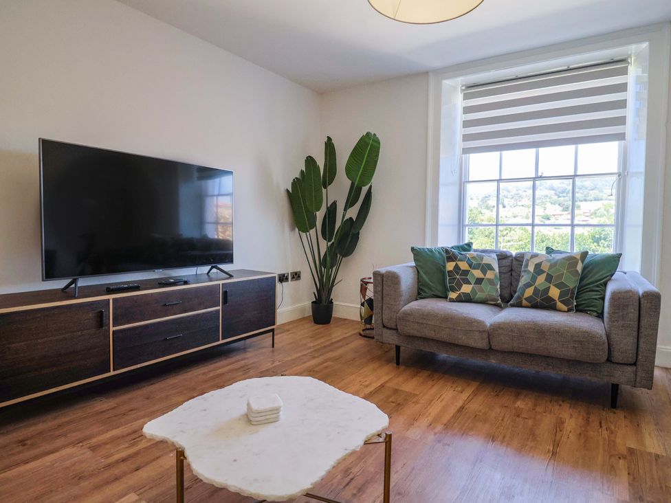 A living room with a television and sofa at Pebble Cove in Lyme Regis