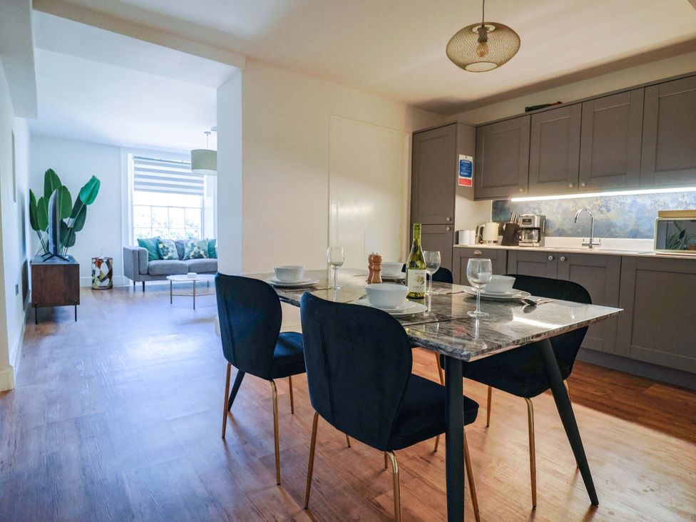 A kitchen with dining area and a sofa at Pebble Cove in Lyme Regis