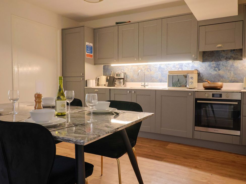 A kitchen with a table set for dining at Pebble Cove in Lyme Regis