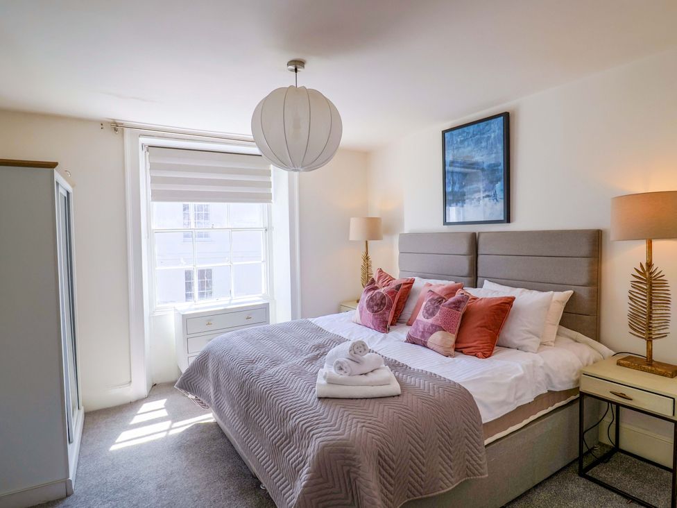 A bedroom with a bed and pillows at Pebble Cove in Lyme Regis