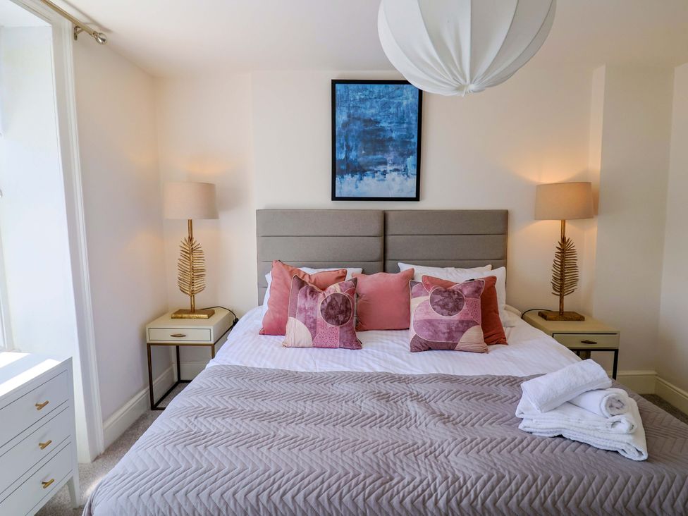 A bedroom with a bed and bedside tables at Pebble Cove in Lyme Regis