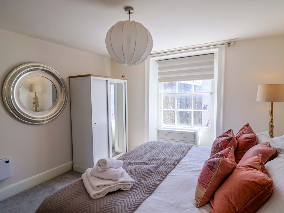 A bedroom with a bed and wardrobe at Pebble Cove in Lyme Regis