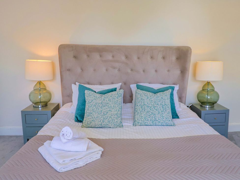 A bedroom with a bed and nightstands at Pebble Cove in Lyme Regis