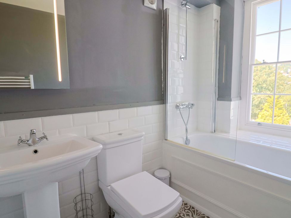 A bathroom with a sink, toilet, and bathtub at Pebble Cove in Lyme Regis