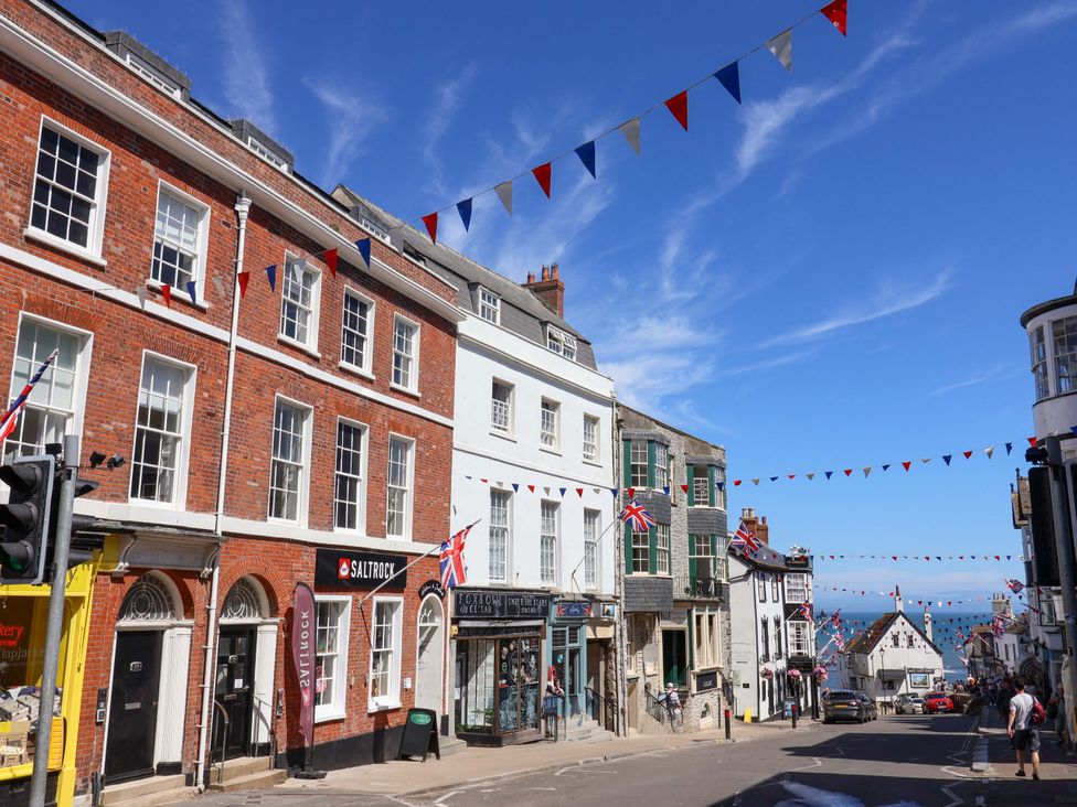 A street scene with buildings and bunting at Pebble Cove in Lyme Regis
