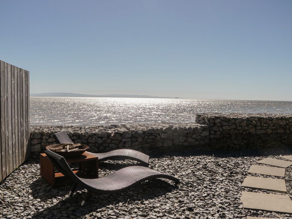 A seating area with beach chairs and a fire pit at Driftwood Cottage, Ulverston