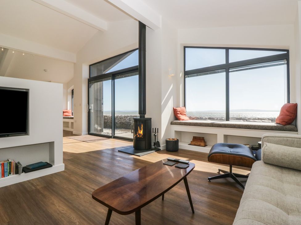 A living room with a fireplace and seating area at Driftwood Cottage in Ulverston