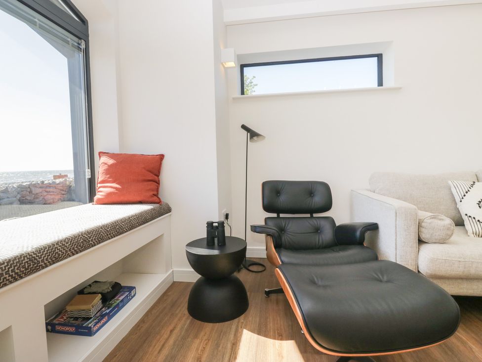 A living room with a chair and side table at Driftwood Cottage in Ulverston