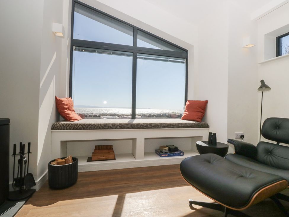 A living room with a window seat and chair at Driftwood Cottage in Ulverston