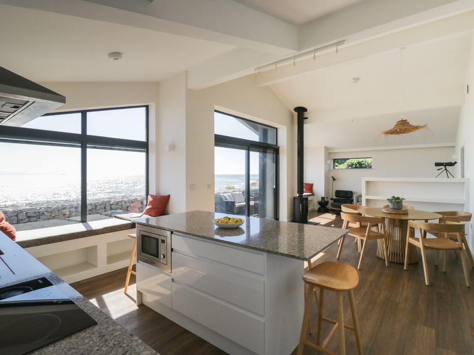 A kitchen with an island and dining area at Driftwood Cottage in Ulverston