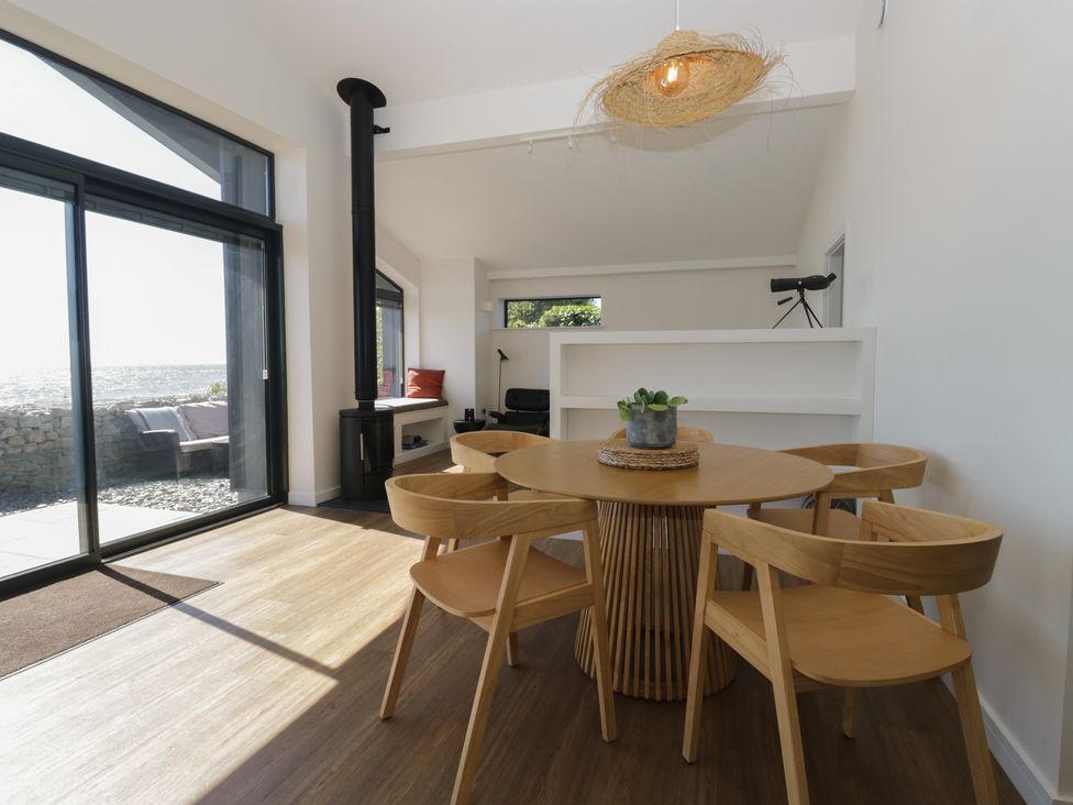 A dining room with a table and chairs at Driftwood Cottage in Ulverston
