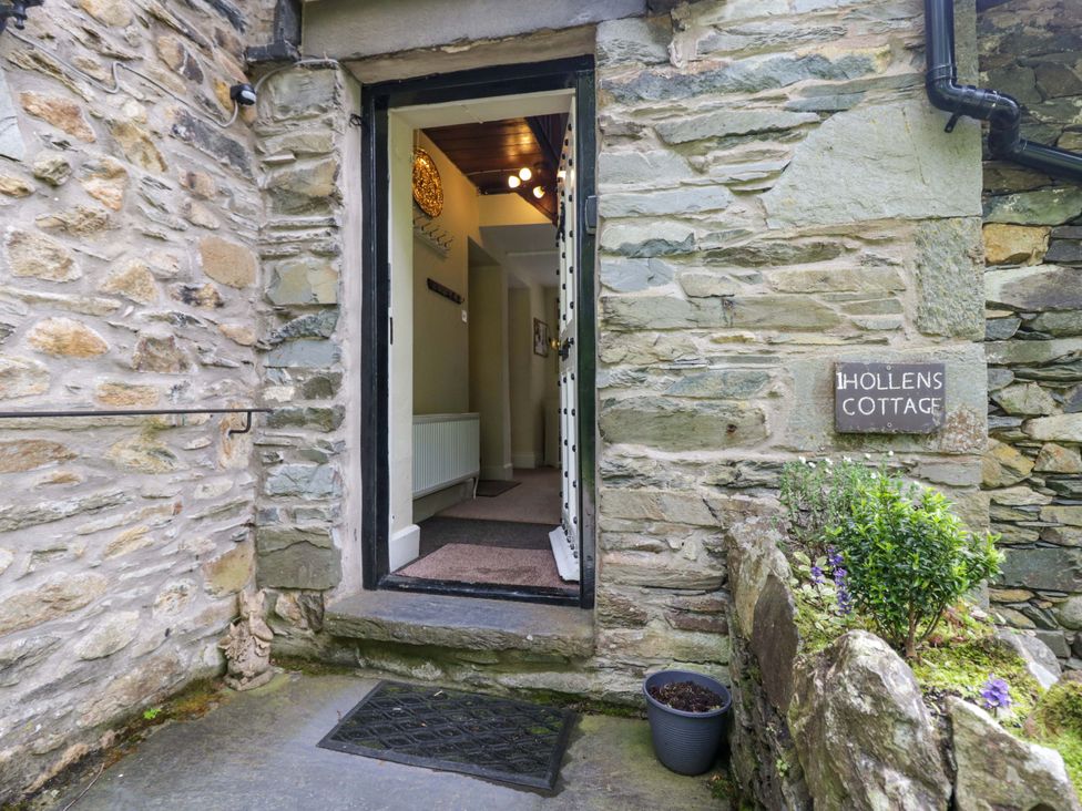 An entrance with a door and stone wall at Hollens Cottage in Grasmere