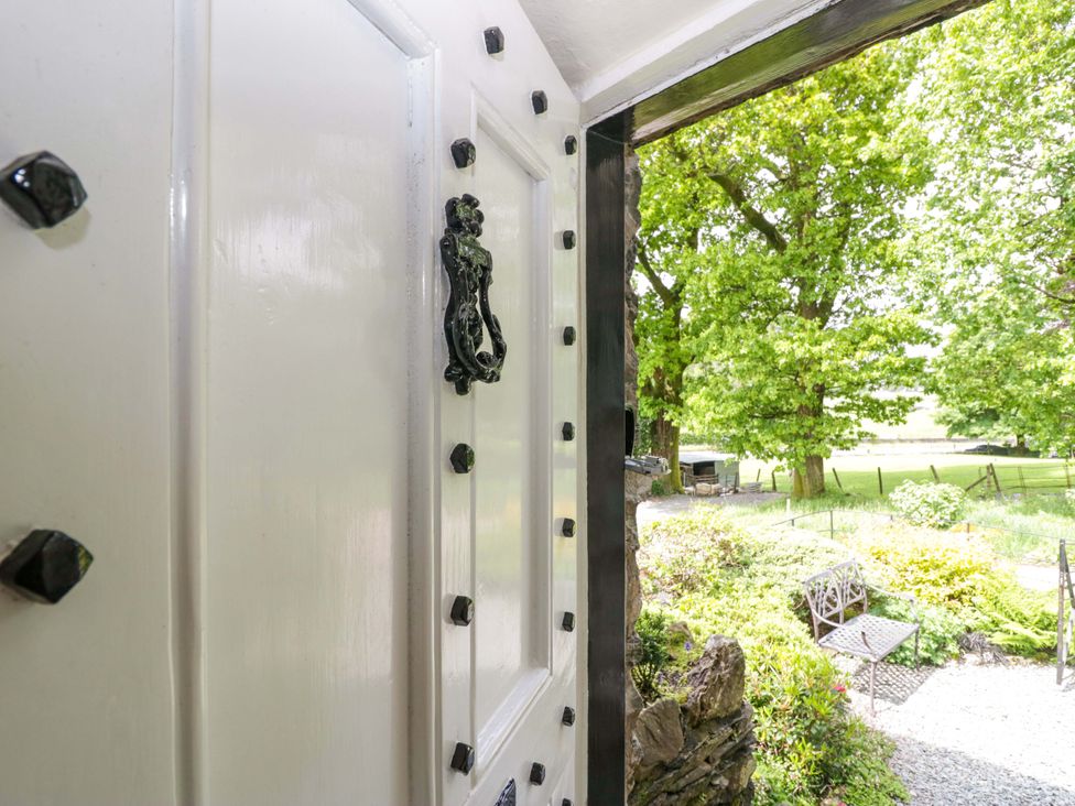 An open door leading to a garden at Hollens Cottage in Grasmere